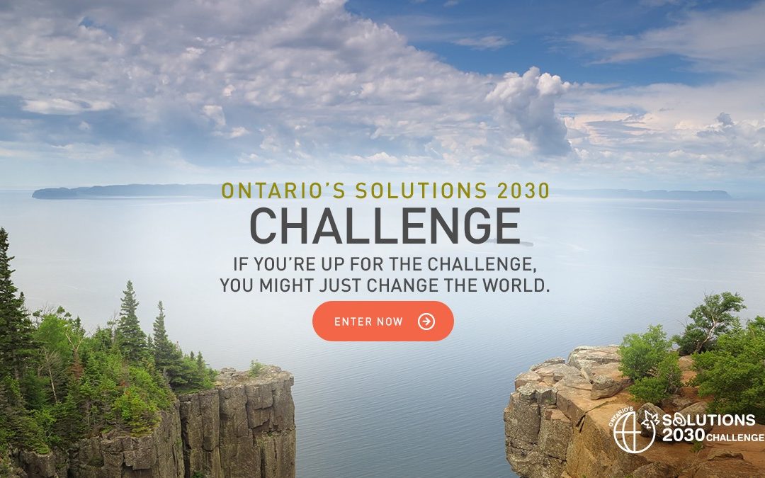 Ontario's solutions 2030 challenge advertisement. the picture shows cliffs on either side of the bottom of the picture with green foliage growing. the middle of the picture shows a vast lake with land off in the distance. There is a bring blue sky with some cloud coverage above.
